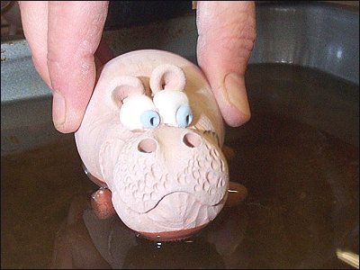  miniature hippo being dipped in molten wax, poor fella 